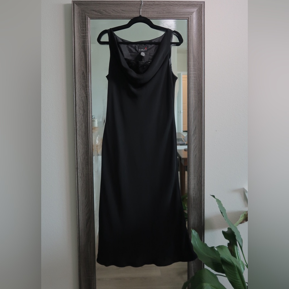 Black sleeveless cocktail dress with draped cowl neckline and peekaboo detail.